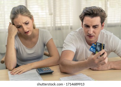 Stressed Young Caucasian Couples Sitting With Hand Holding Credit Cards And Look At Bills Worry About Find Money To Pay Credit Card Debt And All Loan Bills. They Feel Stressful. Financial Problem.