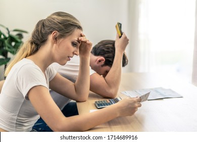 Stressed Young Caucasian Couples Sitting With Hand Holding Credit Cards And Bills Worry About Find Money To Pay Credit Card Debt And All Loan Bills. They Are Feeling Stressful. Financial Problem.