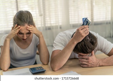 Stressed Young Caucasian Couples Sitting With Hand Holding Credit Cards And Look At Bills Worry About Find Money To Pay Credit Card Debt And All Loan Bills. They Feel Stressful. Financial Problem.