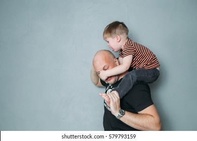 Stressed Young Dad With Two Small Child In His Arms