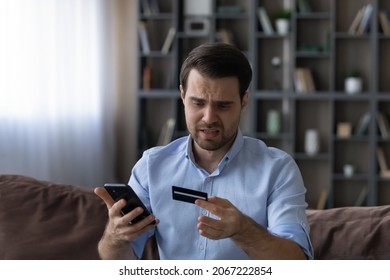 Stressed young man dissatisfied with insecure online money transfer operation, entering payment information in mobile shopping application, suffering from financial problems, bankruptcy concept.