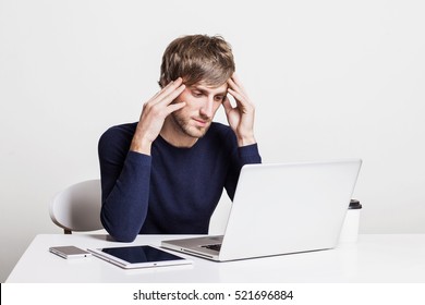 Stressed young man having problems and headache at work. Student using laptop computer at home. Businessman, work from home, distance education, online learning, studying concept
