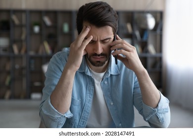 Stressed Young Man Holding Cellphone Conversation, Feeling Displeased With Bad Negative News. Unhappy Nervous Male Client Dissatisfied With Failure, Listening Debt Notification, Bankruptcy Concept.