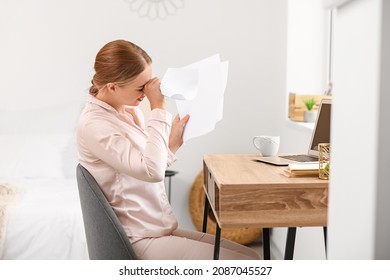 Stressed Young Woman With Bills At Home