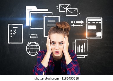 Stressed young woman in checkered shirt sitting near chalkboard with electronic documents and internet icons. Concept of information overload. Toned image