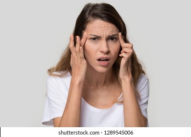 Stressed Young Woman Confused About Facial Wrinkles Aging Skin On Forehead Or Crows Feet Looking At Camera Isolated On Studio Background, Upset Worried Girl Having Headache Touching Temples, Portrait