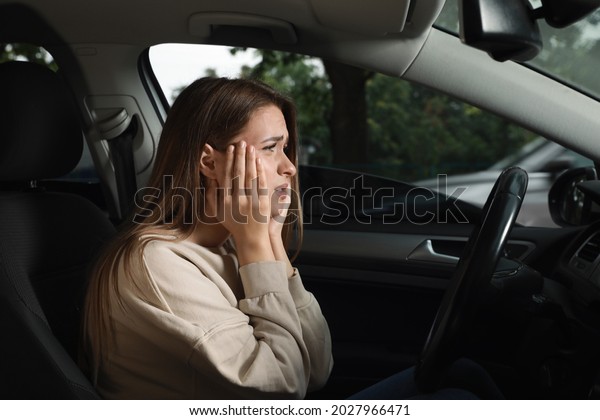 Stressed young\
woman in driver\'s seat of modern\
car