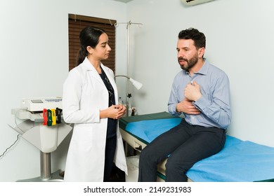 Stressed Young Woman Explaining His Symptoms And Chest Pain To A Female Cardiologist Doctor