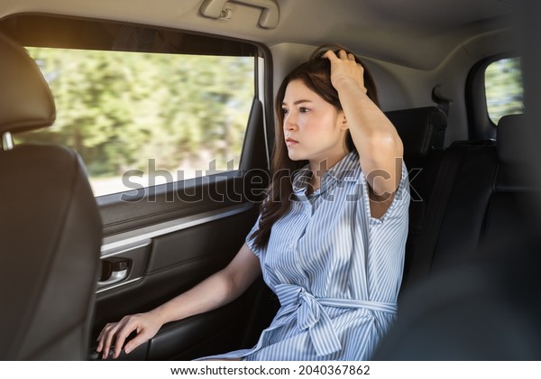 stressed\
young woman sitting in the back seat of car\
