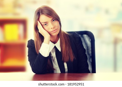 Stressed Young Woman Sitting Behind A Desk