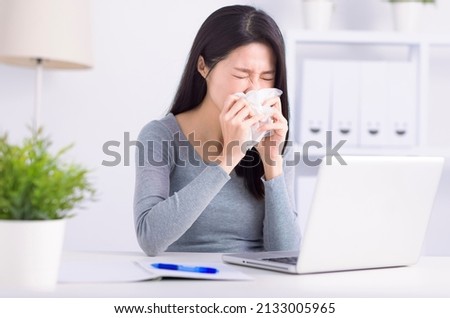 Stressed young  woman sneezing  and working at home office Сток-фото © 