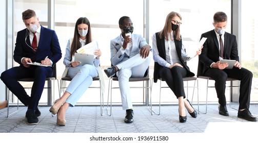 Stressful business people waiting for job interview with face mask, social distancing quarantine during COVID19 affect - Powered by Shutterstock