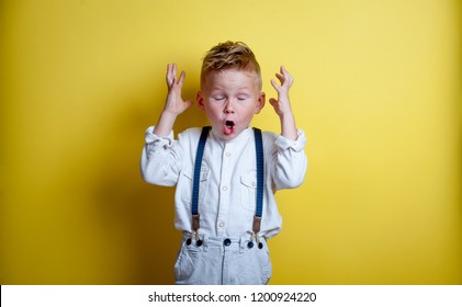 Stressful Child. Sad And Unhappy Child. Upset Toddler Boy. Problem Child With Head In Hands. Cute Boy Shouts. Stressed Child. Boy Shouting On Yellow Background.