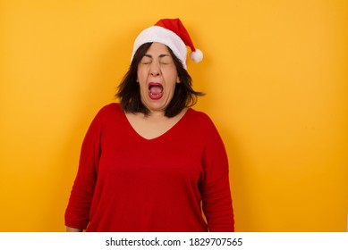 Stressful Middle Aged Woman Wearing Christmas Hat, Screams In Panic, Closes Eyes In Terror, Keeps Hands On Head, Finds Out Terrified News Or Disaster About Best Friend, Can't Believe It. 