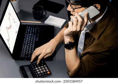 Stressful trader calling to broker while looking on laptop to investing stock market exchange with high value profit, calculating margin of return analysis at over late night at home office. Infobahn. - Powered by Shutterstock