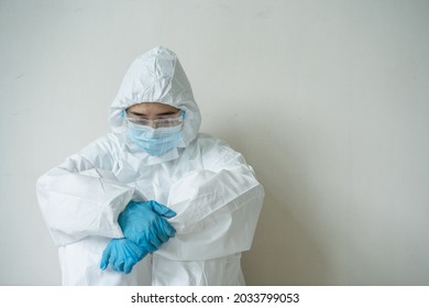 Stressful - Worried Asian Medication Staff Sitting On A Chair Against The Wall, Healthcare Worker Hard Working In Hospital. Overworked Health Care Worker - Nurse Feels Tired.