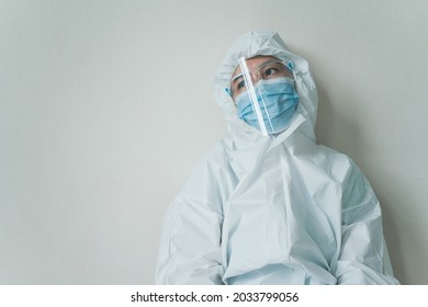 Stressful - Worried Asian Medication Staff Sitting On A Chair Against The Wall, Healthcare Worker Hard Working In Hospital. Overworked Health Care Worker - Nurse Feels Tired.