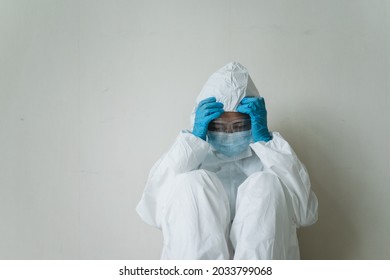 Stressful - Worried Asian Medication Staff Sitting On A Chair Against The Wall, Healthcare Worker Hard Working In Hospital. Overworked Health Care Worker - Nurse Feels Tired.