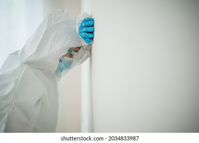 Stressful - Worried Asian Medication Staff Sitting On A Chair Against The Wall, Healthcare Worker Hard Working In Hospital. Overworked Health Care Worker - Nurse Feels Tired.