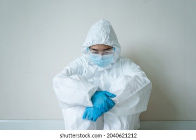 Stressful - Worried Asian Medication Staff Sitting On A Chair Against The Wall, Healthcare Worker Hard Working In Hospital. Overworked Health Care Worker - Nurse Feels Tired.