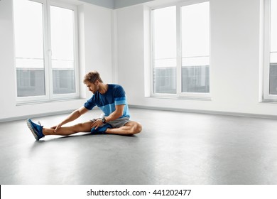 Stretch Body Exercise. Handsome Man Stretching Before Workout. Healthy Muscular Athletic Active Fitness Male Model In Fashion Sportswear Doing Stretches, Warming Up, Exercising Indoors. Sports Concept