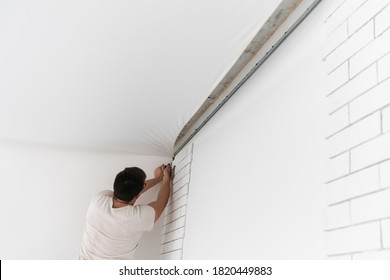 Stretch Ceiling. Workers Stretch The Suspended Ceiling In The Room. Ceiling Installation.