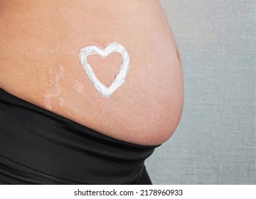 Stretch Marks On The Skin During Pregnancy. Skin Care During Pregnancy Concept. Heart Shape Created From Cream. 