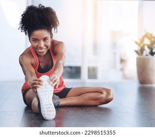 Stretch it out before you work it out. a young woman doing stretch exercises in a studio.
