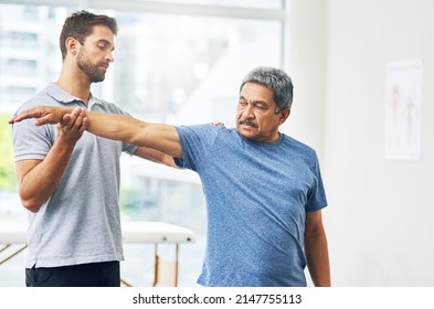 Stretch out for me. Cropped shot of a young male physiotherapist assisting a senior patient in recovery. - Powered by Shutterstock