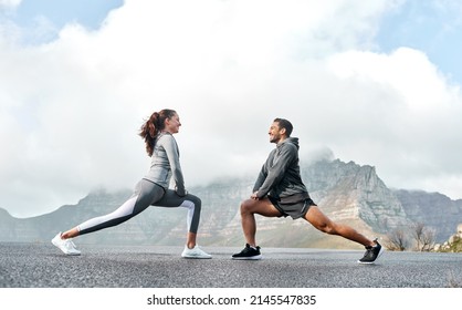 Stretch well to increase your speed and stride. Shot of a sporty young man and woman stretching their legs while exercising outdoors. - Powered by Shutterstock