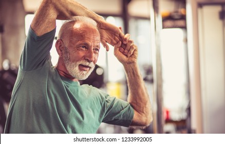 Stretch Your Muscles Before All Exercises. Senior Man At Gym Working Exercise. Close Up.