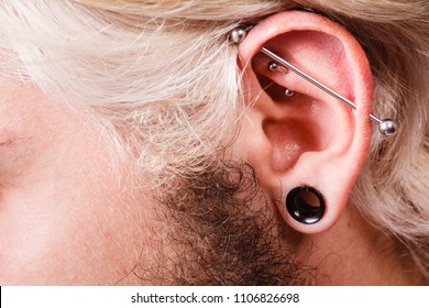 Stretched Lobe Piercing, Grunge Concept. Pierced Man Ear With Black Plug Tunnel. Industrial And Rook