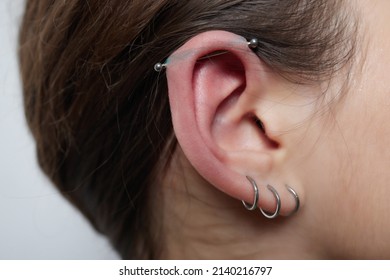 Stretched lobe piercing, grunge concept. Pierced woman ear with black plug tunnel. industrial and rook.