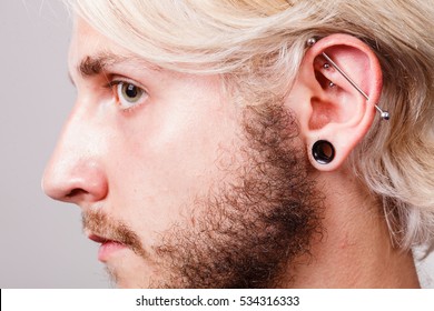 Stretched Lobe Piercing, Grunge Concept. Pierced Man Ear With Black Plug Tunnel. Industrial And Rook