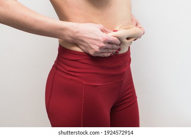 Stretched Skin Of The Abdomen In The Hands Close-up, Cosmetic Problem Of The Abdomen, Skin After Pregnancy, Sagging Skin After Losing Weight