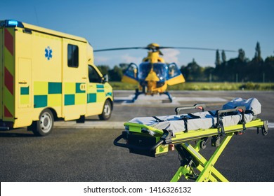 Stretcher against ambulance car and helicopter of emergency medical service. Themes rescue, help and hope.