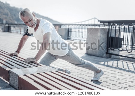 Similar – Athletic man warming up before running.