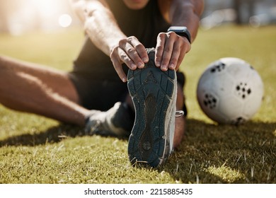 Stretching, foot and soccer man on field for sports training, exercise wellness or legs muscle health. Professional football person with sneakers or shoes for game warmup, workout outdoor on a pitch