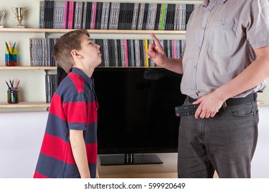 Strict Dad Holding The Remote Control Not Allowing Watching The TV For His Son 