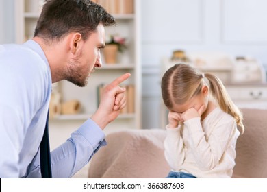 Strict father punishing his daughter 