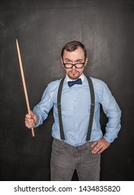 Strict Teacher In Eyeglasses With Pointer On Blackboard Background