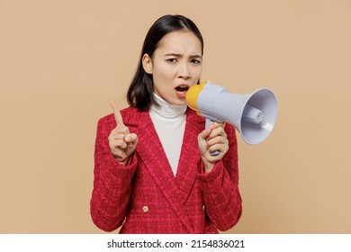 Strict woman of Asian ethnicity 20s wear red jacket hold scream in megaphone announces discounts sale Hurry up point finger up warns isolated on plain pastel beige background People lifestyle concept