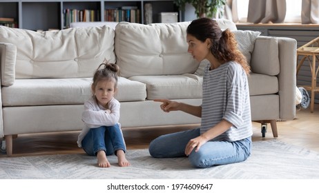Strict young Caucasian mother talk lecture ill-behaved stubborn small preschooler daughter at home. Serious mom scold unhappy naughty little girl child kid. Family fight, generation gap concept.