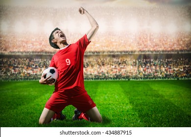 Striker Soccer Football Player In Red Team Concept Celebrating Goal In The Stadium During Match

