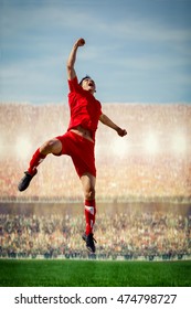 Striker Soccer Football Player In Red Team Concept Celebrating Goal In The Stadium During Match By Jump And Punching In The Air