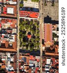 A striking aerial, cenital view of the central plaza in San Cristóbal de las Casas, Chiapas, Mexico. The image highlights the symmetrical layout of the plaza.