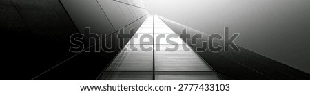 A striking black and white image capturing the geometric lines and vanishing point of a contemporary buildings interior, emphasizing light and shadow.