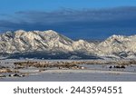 the  striking boulder flatirons and  snow -capped peaks of the front range of the colorado rocky mountains in winter as seen from broomfield, colorado, in early morning