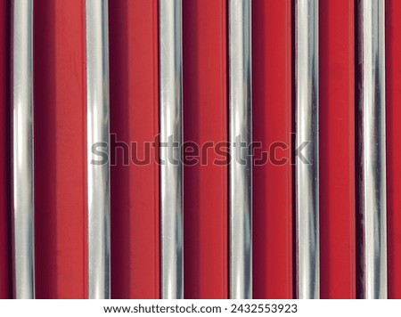 Striking Contrast: Red Metal Shutters with Silver Bars. A Bold Red Texture Adds Vibrancy to the Industrial Design. Close up