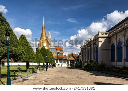 A striking large building with a distinguished gold spire reaching towards the sky.